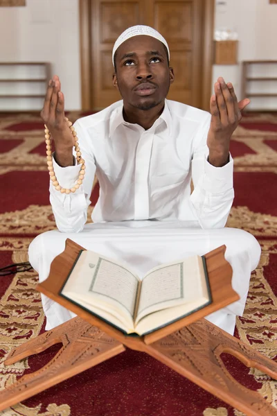 Unga afrikanska muslimska killen läser Koranen — Stockfoto