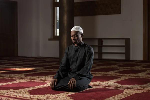 Africano muçulmano homem está orando na mesquita — Fotografia de Stock