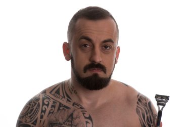 Tek kullanımlık ustura tutan dövmeli adam Styling sakal