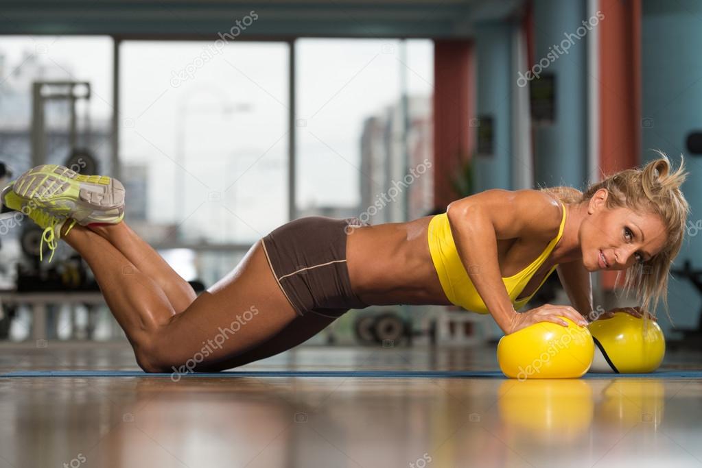 Woman Doing Push Up Exercise On Yellow Balls