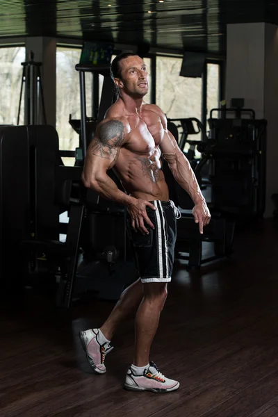 Homme dans la salle de gym montrant son corps bien formé — Photo