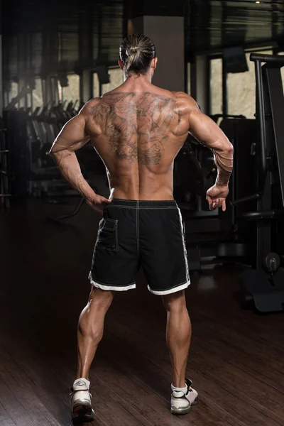 Hombre en el gimnasio mostrando su cuerpo bien entrenado —  Fotos de Stock