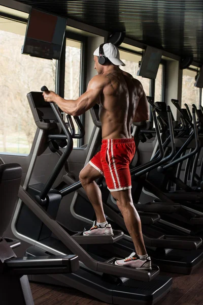 Dojrzały człowiek robi eliptyczne Walker aerobiku w sali gimnastycznej — Zdjęcie stockowe