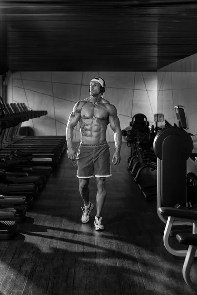Porträt eines Mannes im Fitnessstudio, der Musik hört — Stockfoto
