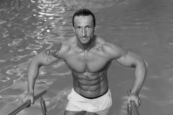 Hombre descansando relajado al borde de la piscina — Foto de Stock