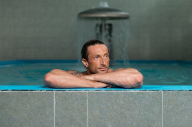 Yüzme Havuzu kenarında oturan adam rahat