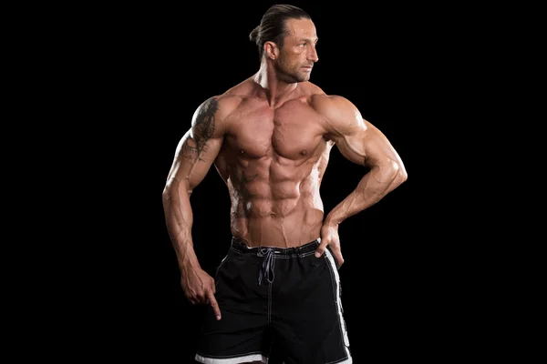 Muskulös Bodybuilder Man poserar över svart bakgrund — Stockfoto