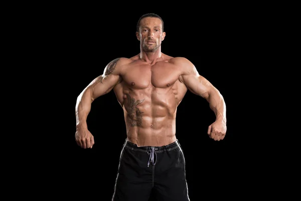 Muskulöser Bodybuilder Mann posiert vor schwarzem Hintergrund — Stockfoto