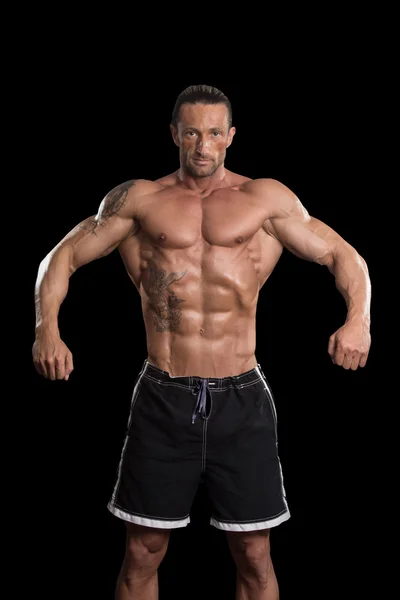 Musclé Bodybuilder Guy posant sur fond noir — Photo