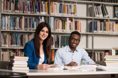 Kütüphanede oturan genç öğrenci grubu