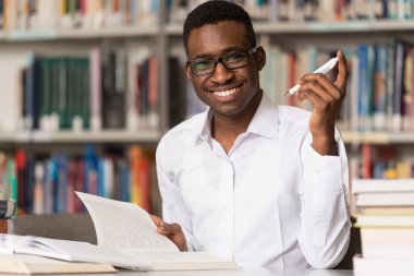 Kütüphanede oturan genç öğrenci