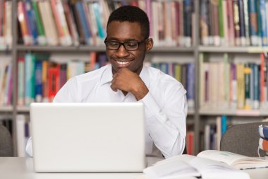Kütüphane içinde Laptop ile mutlu Afrika erkek öğrenci