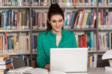 Kütüphane içinde Laptop ile mutlu kız öğrenci