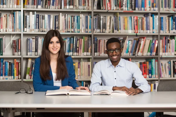 Grupo de jóvenes estudiantes sentados en la biblioteca —  Fotos de Stock