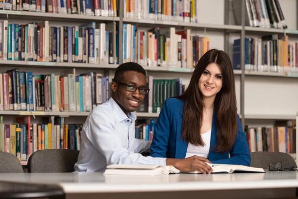 Personas que estudian en una biblioteca — Foto de Stock