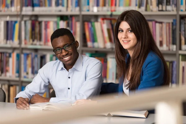 Pessoas estudando em uma biblioteca — Fotografia de Stock