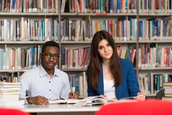 Groupe de jeunes étudiants assis à la bibliothèque — Photo