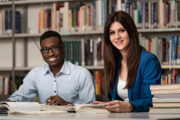 Para studentów w bibliotece — Zdjęcie stockowe