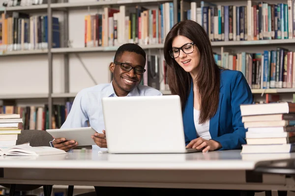 Glada studenter som arbetar med Laptop i biblioteket — Stockfoto