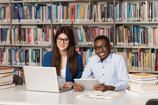 Studenti pomocí tabletového počítače v knihovně — Stock fotografie