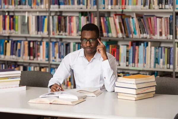 Jonge Student zitten in de bibliotheek — Stockfoto