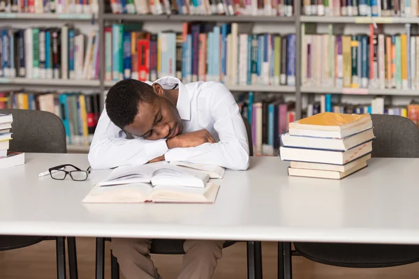 Africain mâle étudiant dormir dans la bibliothèque — Photo