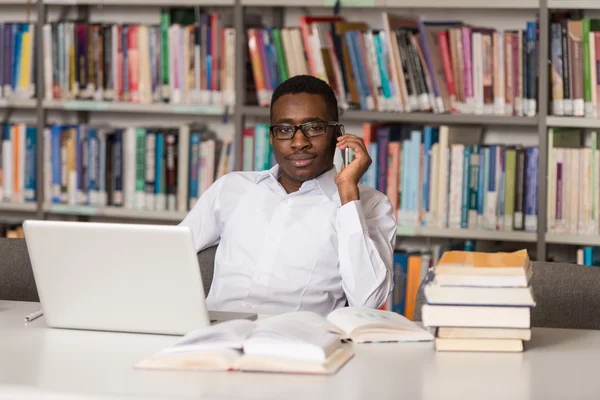 図書館に電話で話している男子生徒 — ストック写真