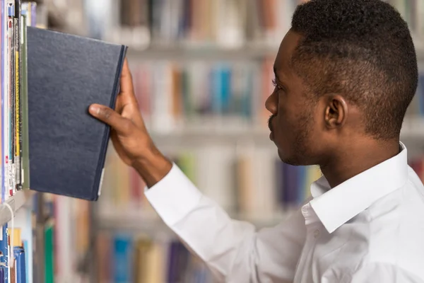 Male College Student In een bibliotheek — Stockfoto