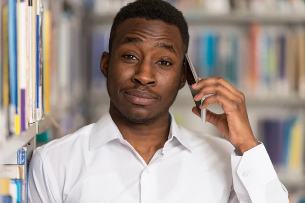 Handsome College Student Using Mobile Phone In Library — Stock Photo, Image