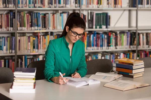 Kvinnlig student i ett bibliotek — Stockfoto