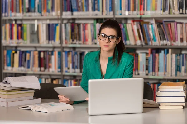 Ung Student med sin Laptop i ett bibliotek — Stockfoto