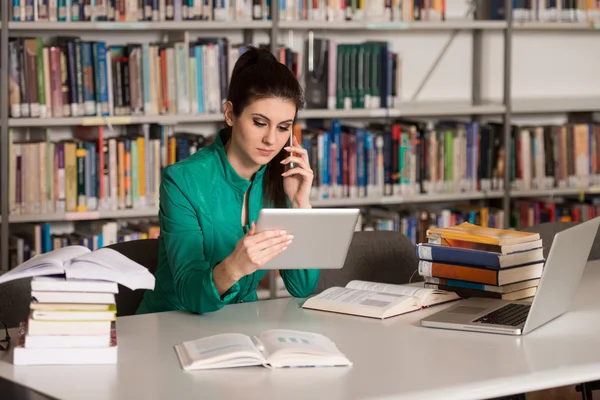 Étudiante parlant au téléphone à la bibliothèque — Photo