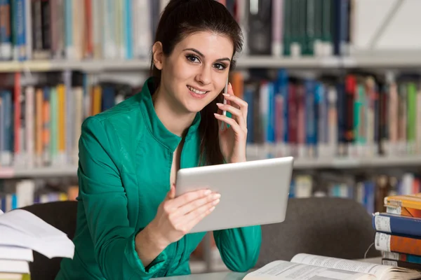 Étudiante parlant au téléphone à la bibliothèque — Photo