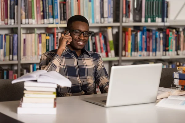 Manlig Student prata i telefon i biblioteket — Stockfoto