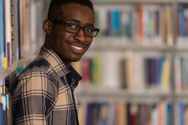 Heureux étudiant masculin avec livre dans la bibliothèque — Photo