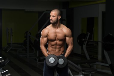 Vücut geliştirmeci omuz Dumbbells ile egzersiz