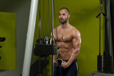 Kaslı adam trisepsler için ağır ağırlık egzersizi yapıyor.