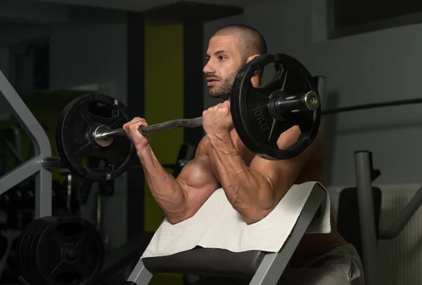 Bodybuilder uitoefening biceps met barbell — Stockfoto