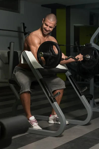 Bodybuilder uitoefening biceps met barbell — Stockfoto