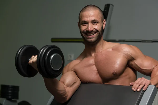 Pazı dumbbells ile egzersiz vücut geliştirmeci — Stok fotoğraf