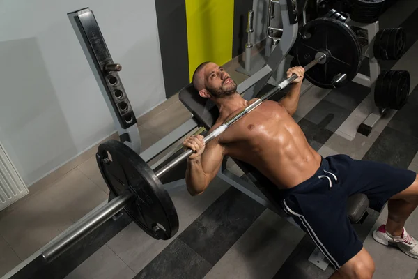 Bodybuilder Exercising Chest With Barbell