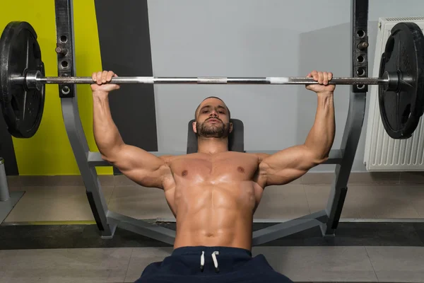 Gezonde jonge Man doen van bankdrukken oefening — Stockfoto