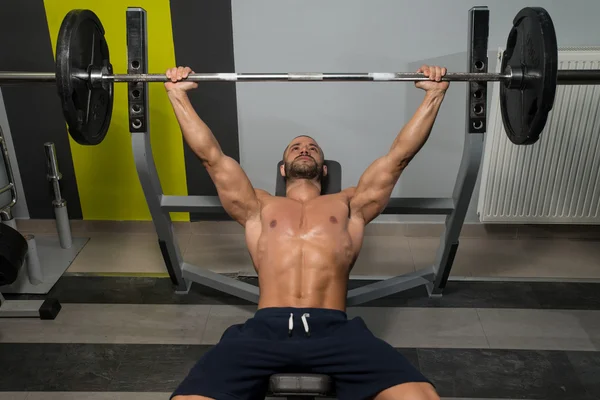 Imprensa do banco do exercício do halterofilista com barra — Fotografia de Stock