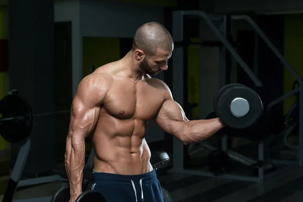 Culturista masculino haciendo ejercicio de peso pesado para bíceps — Foto de Stock