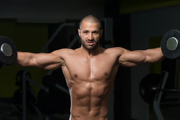 Mužského kulturista dělat těžké váze cvičení na ramena — Stock fotografie