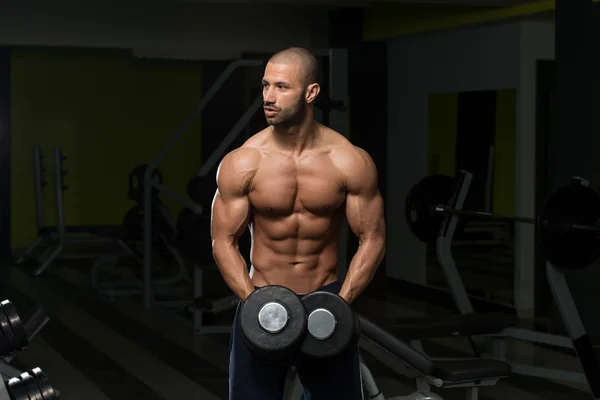 Bodybuilder trainiert Schultern mit Kurzhanteln — Stockfoto