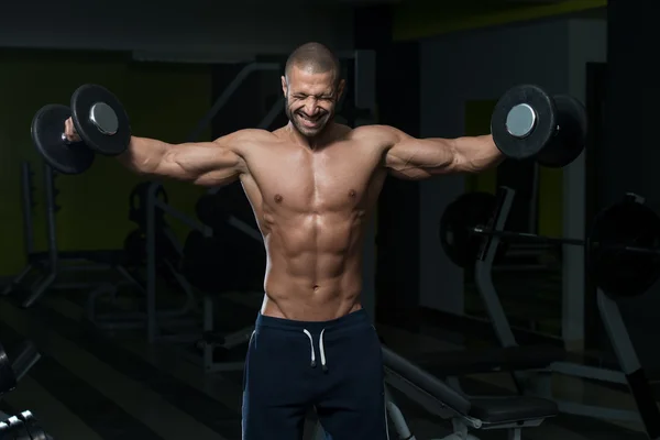 Fisiculturista masculino fazendo exercício de peso pesado para ombros — Fotografia de Stock