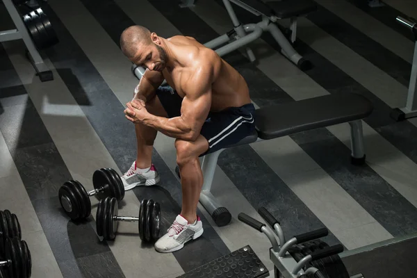 Gesunder junger Mann ruht sich in Fitnessstudio aus — Stockfoto