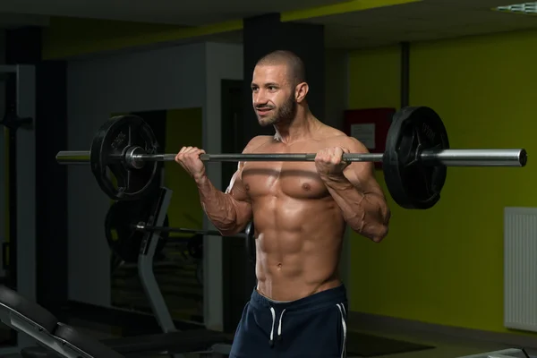 Bodybuilder uitoefening biceps met barbell — Stockfoto