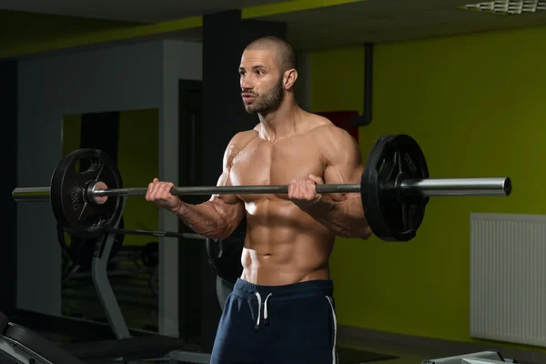 Fisiculturista exercendo bíceps com Barbell — Fotografia de Stock